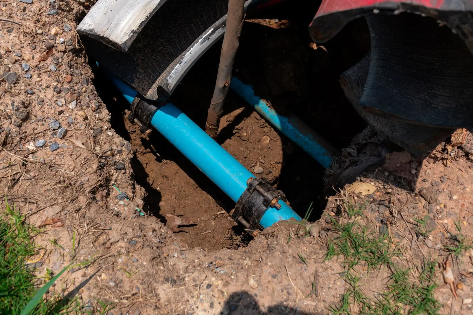 A blue water line in a dug-out trench