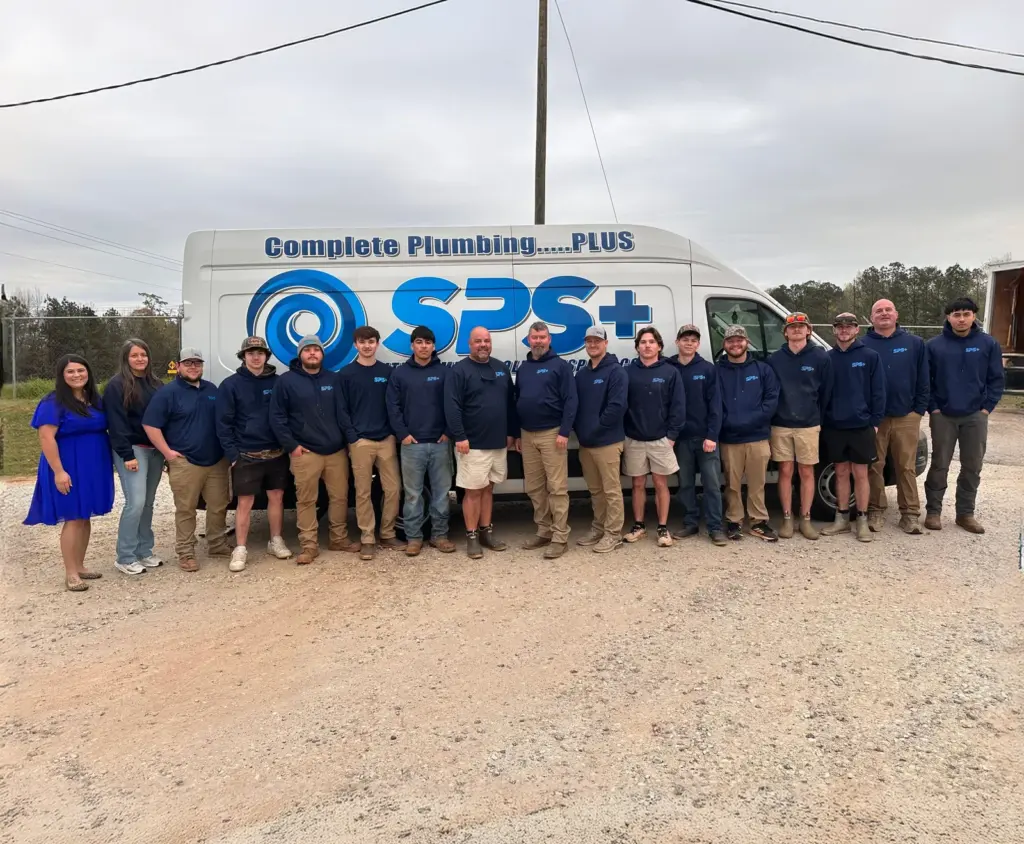 The Smith Plumbing Solutions Plus team in front of a company van