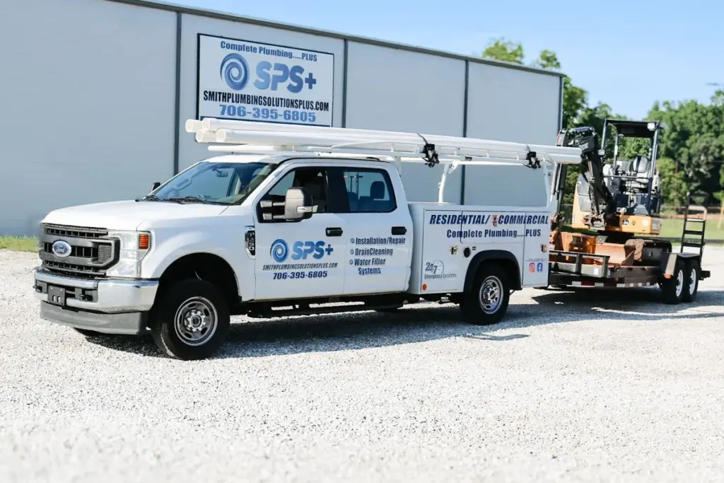 A Smith Plumbing Solutions Plus service truck with its equipment trailer